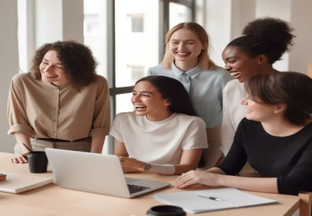Five women laughing at something on a Laptop screen